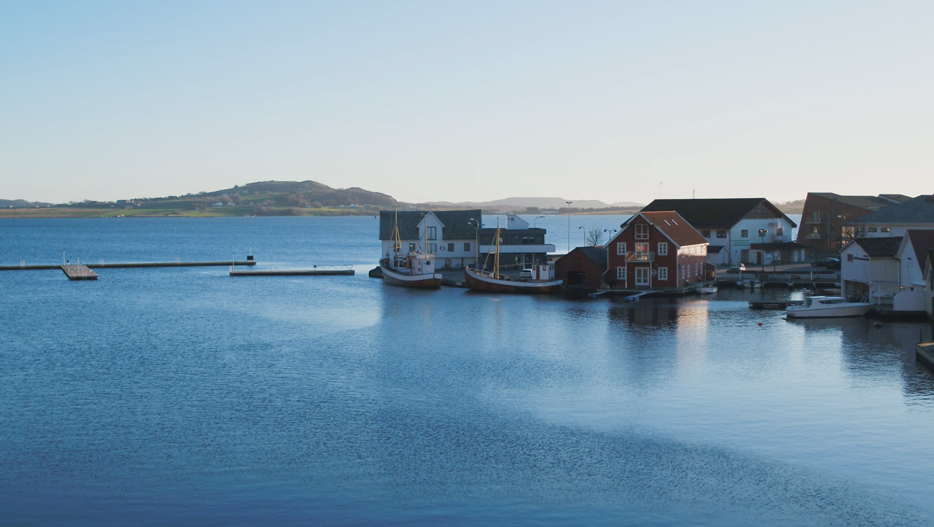 Kystbilde med fiskebåter og naust