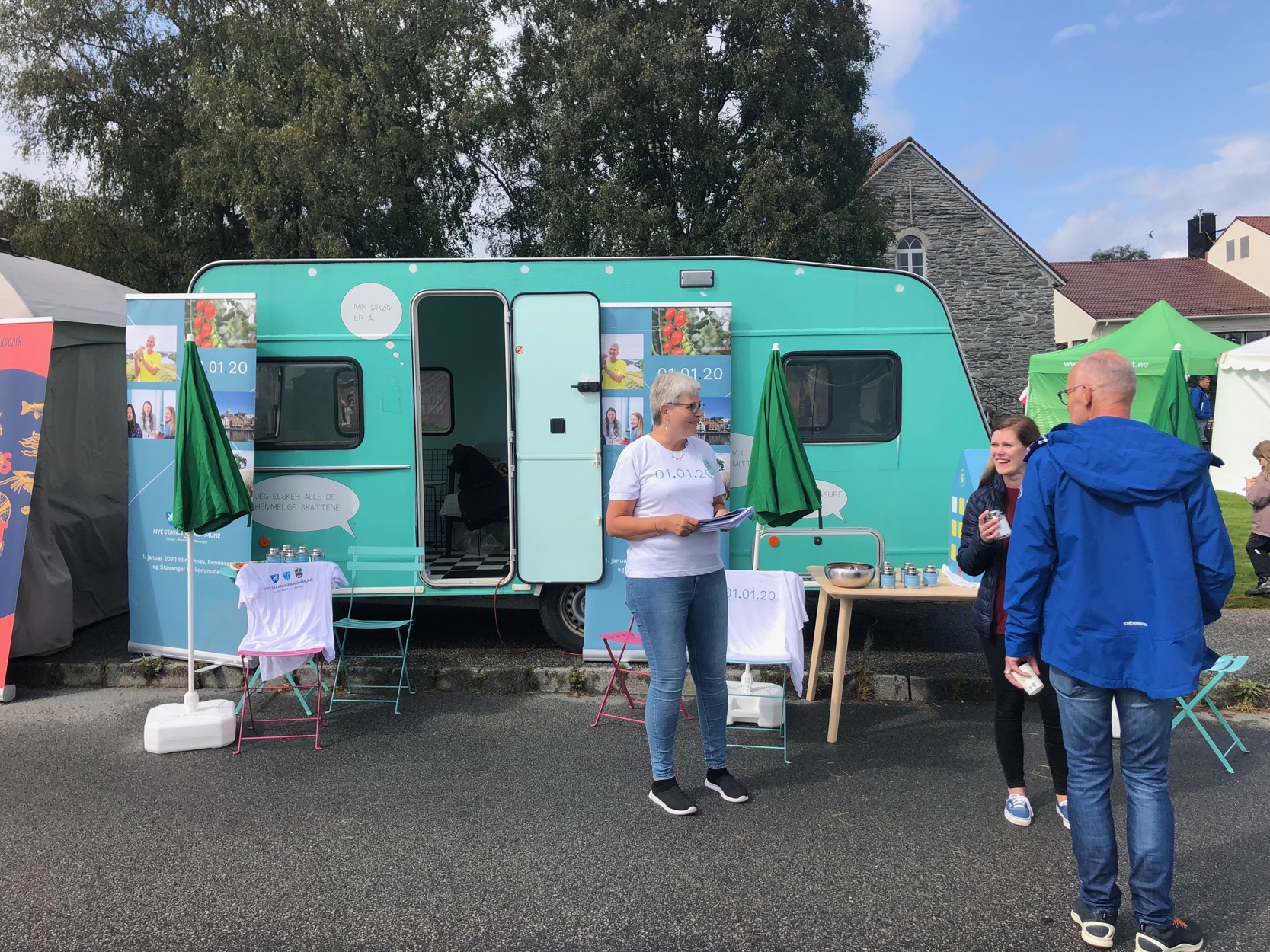 Personer snakker sammen foran campingvogn