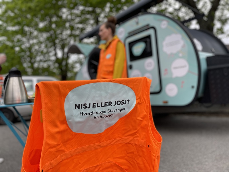En oransje vest med teksten nisj eller josj henger foran campingvognen.