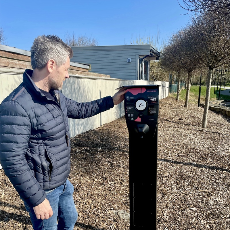 Trond Thorbjørnsen, rådgiver i smartby-avdelingen,  ved elbil-laderen ved Hundvåg svømmehall.

