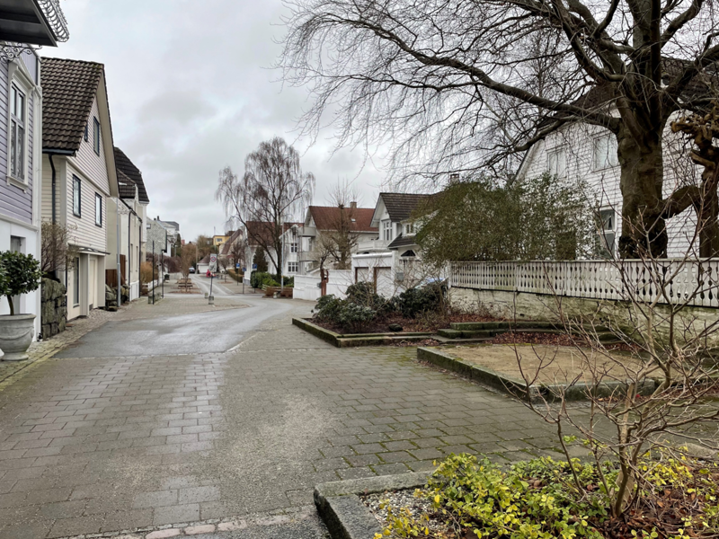 Gatetun i Oscars gate med belegningsstein, sandkasse og innrammede bed som stikker ut i gaten slik at den ser mer ut som et tun, enn som en bilagte.