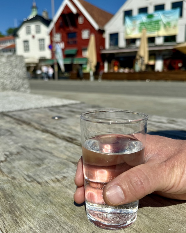 Et glass med vann med skagenkaien i bakgrunnen