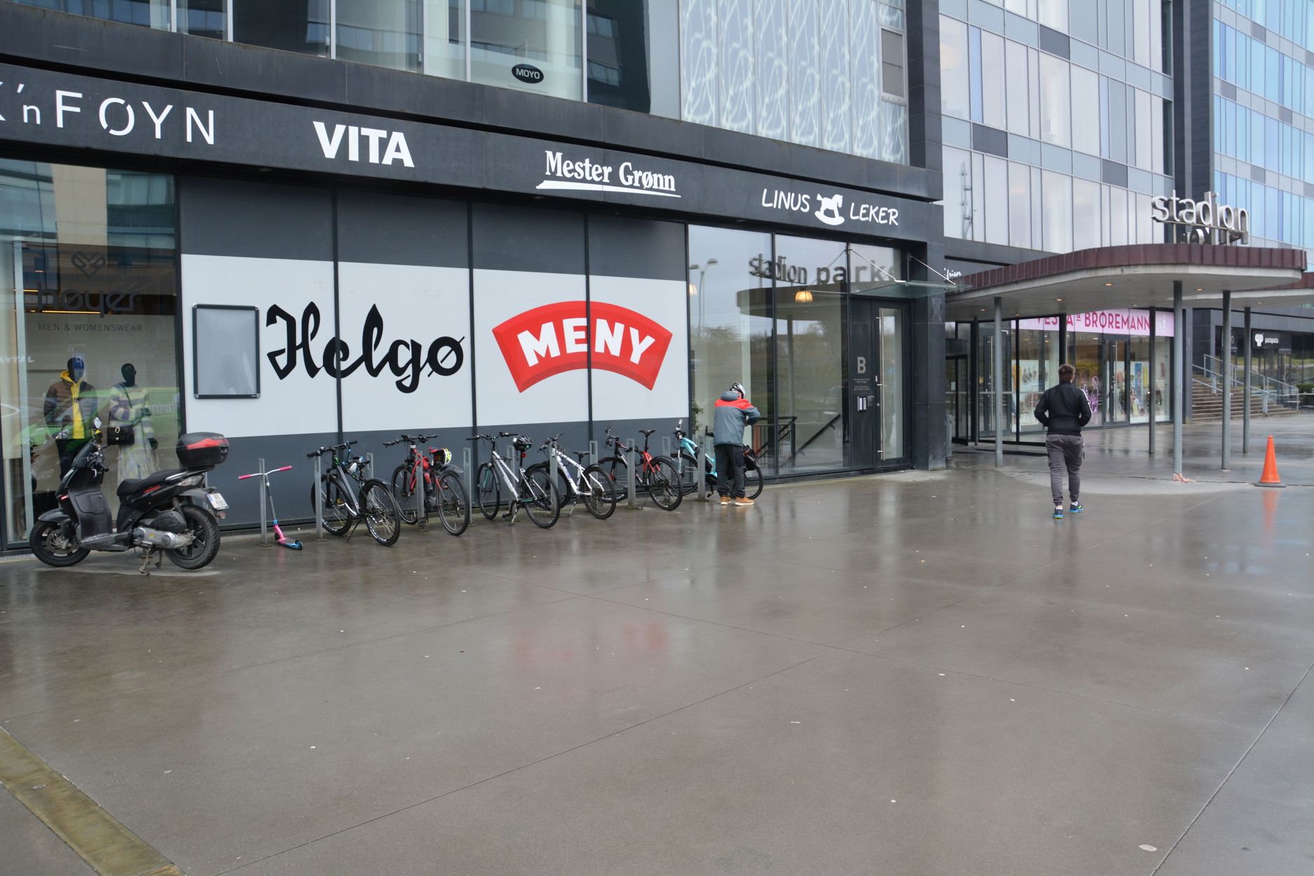 Rett ved siden av inngangen til et handlesenter er flere sykkelstativer montert.